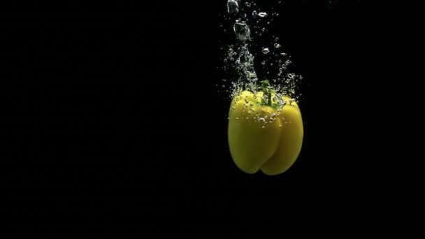 Pimenta Amarela Sino Que Cai Água Limpa Girando Com Muitas — Vídeo de Stock