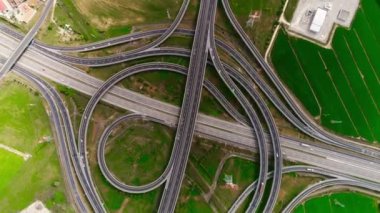 Hava görüntüsü. Otoyol, çok katlı kavşak yolu ve hareket halindeki arabalar. Arabalar çok katlı bir yerde hareket ediyor.