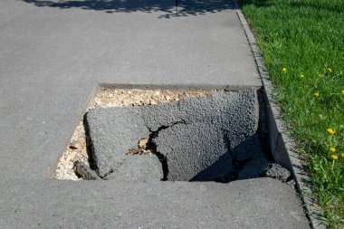 Yazın asfaltta tehlikeli bir çukur. Asfalt yol çökmüş ve çökmüş.