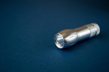 Mavi arkaplanda, kopyalama alanı olan gümüş cep feneri izole edilmiş. Çok az düşünüyorum. En küçük şey