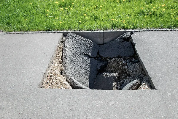 Yazın asfaltta tehlikeli bir çukur. Asfalt yol çökmüş ve çökmüş.