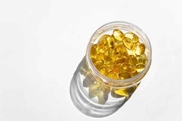 Omega 3 vitamin takviyeli şeffaf kavanoz, beyaz arka planda izole balık yağı.