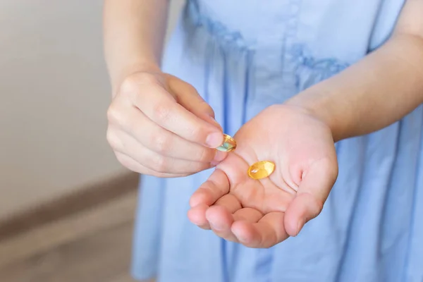 Omega 3 vitamini ve balık yağıyla el ele tutuşan kız.