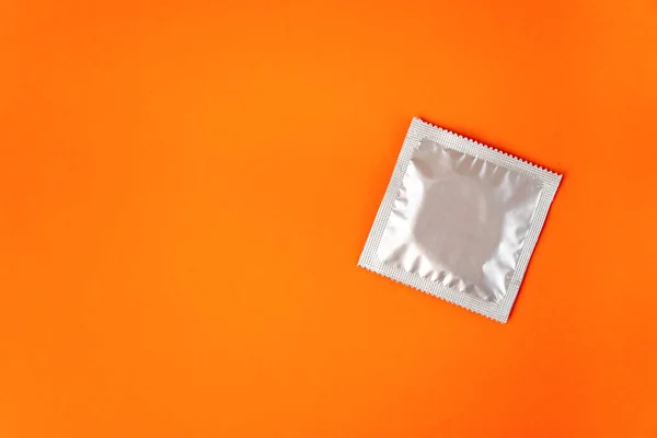 Oversikt Ett Kondom Sølvemballasje Isolert Oransje Bakgrunn Med Kopiplass stockbilde