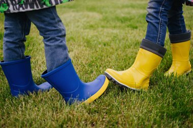 Yeni bir selamlama şekli. Yeni normal. İki insan, kucaklaşma ya da tokalaşma yerine yeni bir selamlama şekli sergilemek için lastik botlarını çarpıştırıyor. Sosyal mesafe. Sağlık hizmetleri