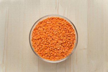 Yuvarlak kasede ahşap arka planda çiğ turuncu İran mercimeği