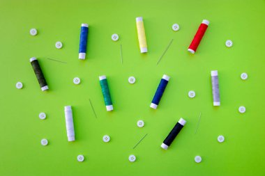 Fotokopi alanı olan renkli dikiş malzemelerinin arka planı. İplik makaraları, düğmeler, iğneler