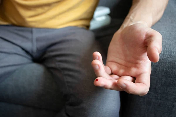 Adam şeker seviyesindeki kanı kontrol ediyor. Evde yapılan tıbbi testler. Kan şekeri testi kavramı. Kan damlalı parmak. Glisemi, diyabet. Adım adım talimat. Adım 2