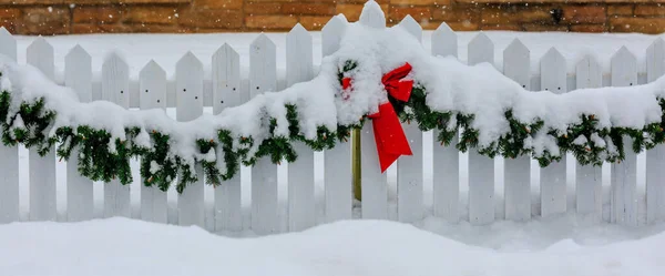 Белый Забор Украшенный Рождество Красным Луком Зеленой Гирляндой Снегу — стоковое фото