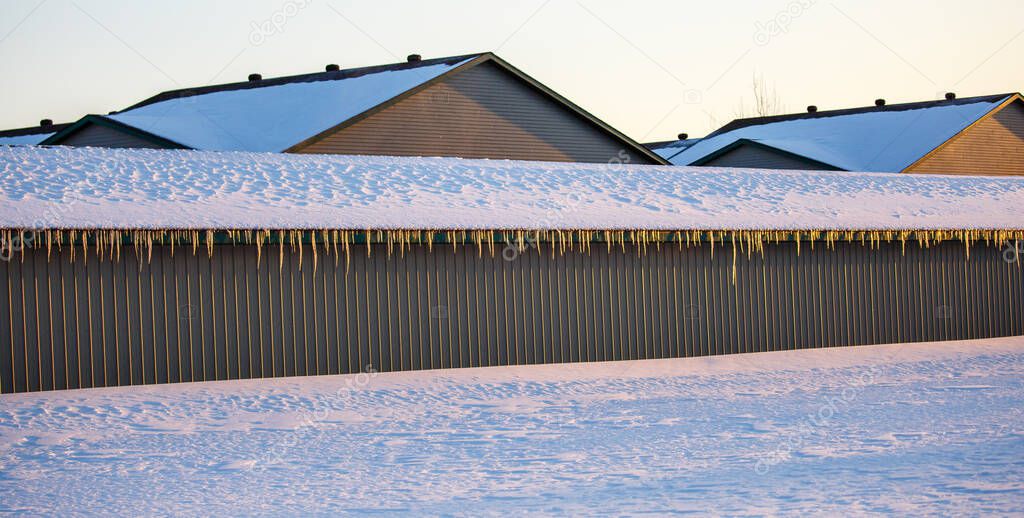 Long building with icicles hanging off of the roof in Wisconsin