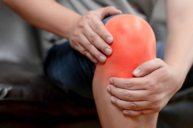 Sıkı çalışma yüzünden diz ağrısı çeken genç bir adam, insan vücudu, ofis sendromu, kemik ve eklem hastalıkları, sağlık ve tıbbi bakım kavramları,.