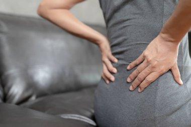 Çok çalıştığı için bel ağrısı çeken kadın, insan vücudu, ofis sendromu, kemik ve eklem hastalıkları, sağlık ve tıbbi bakım kavramları....