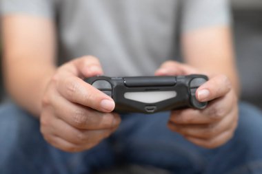 Evde video oyunu oynayan adamın ellerini kapat. Oyuncu eğlence görüntüsü konsepti.