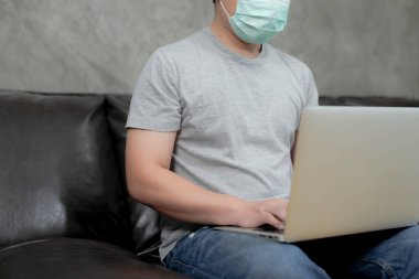 Taylandlı genç adam yüz maskesi takıyor, bilgisayardan bilgisayar konuşmalarıyla arıyor, internet sohbetlerinde iş öğreniyor, uzaktan internet üzerinden iletişim kuruyor, korona virüsü zamanla yayılıyor. Ev fikirlerinden çalışmak, iş kavramı evden.