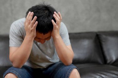 Genç adam baş ağrısından muzdarip, başının ne kadar ağrıdığını gösteren bir resim, acı çekiyor, perişan ve bitkin görünüyor, sağlık ve sağlık sigortasını ve.