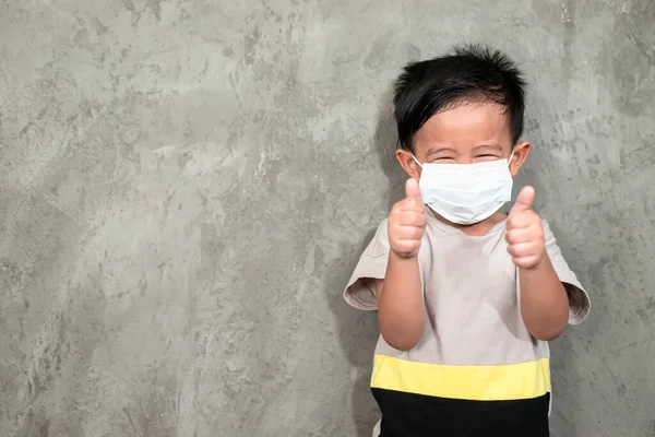 A boy wearing medical face mask for pollution or coronavirus,child itchy eyes and nose, Kid scratching nose while wearing protection mask.Protection against contagious disease, coronavirus.