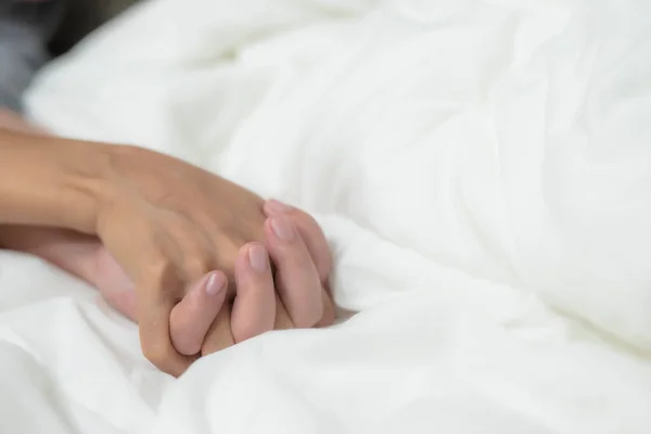 Erkek ve kadının elleri yatağa dokunuyor, prezervatif güvenli seks konsepti veriyor enfeksiyonu önlüyor ve doğum oranını ya da güvenli prezervatifleri kontrol ediyor. Dünya AIDS Günü