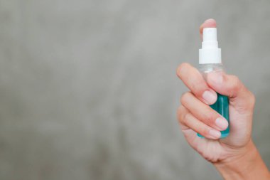 Bir kadının eli, Corona COVID-19 ve SARS Cov 2 enfeksiyonunu önlemek için antiseptik spay ile temizlik yapıyor. Evden çalışmak.