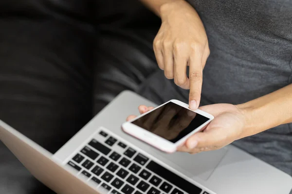 Çalışan kadın akıllı bir telefon ve bilgisayarla çalışıyor. Kadınların teknolojiyle çalışması kavramı.