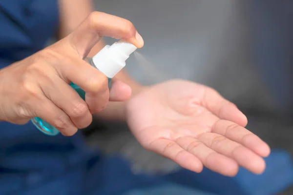 Bir kadının eli, Corona COVID-19 ve SARS Cov 2 enfeksiyonunu önlemek için antiseptik spay ile ellerini temizliyor. Evden çalışmak.
