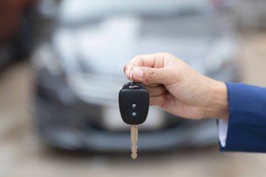 Satıcının yeni sahibine anahtar verip otomobil fuarında el sıkışması. Araba satışı, anlaşma, konsept.