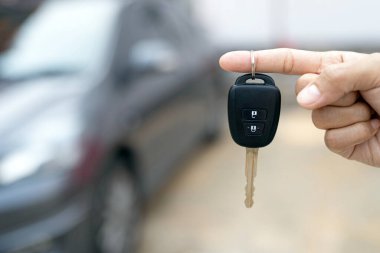 Satıcının yeni sahibine anahtar verip otomobil fuarında el sıkışması. Araba satışı, anlaşma, konsept.