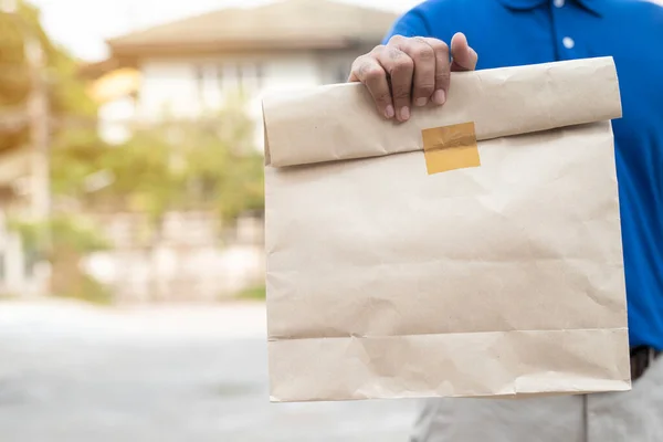 Paket yemek, yiyecek teslimatı konsepti için kağıt kutular tutan genç adam...