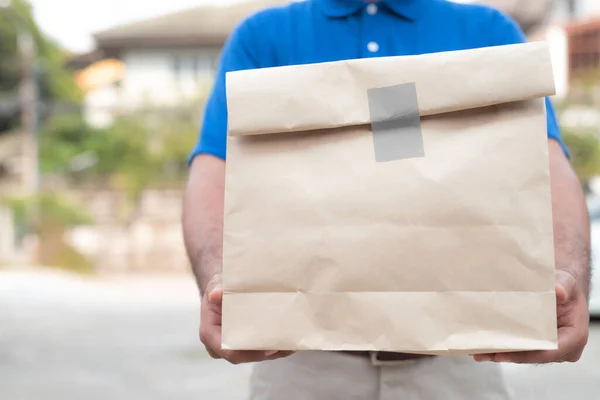 Paket yemek, yiyecek teslimatı konsepti için kağıt kutular tutan genç adam...