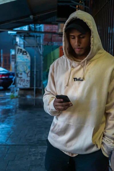 Telefonundaki kapüşonlu model Perth, Batı Avustralya 'da park halindeki arabalarla dolu binaya yerleştirilmiş.