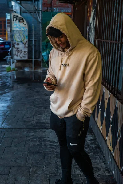 Telefonundaki kapüşonlu model Perth, Batı Avustralya 'da park halindeki arabalarla dolu binaya yerleştirilmiş.