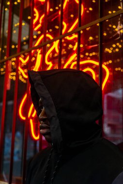 Neon tabelanın yanında poz veren adam ağzından çıkan alevler gibi görünüyor.