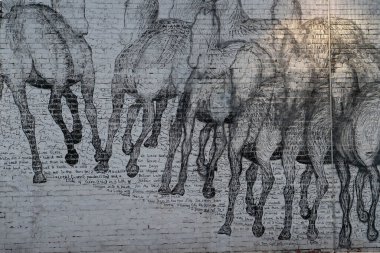 Batı Avustralya 'da Perth' te bir otoparkın ortasında beyaz bir arka planda dört nala giden atların büyük bir duvar resmi.