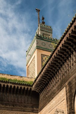 İslam Okulu medrese Bou Inania, Fez, Fas avludan görüntüleyin. Mimari ve kule caminin ayrıntılarını. Mavi gökyüzü, beyaz bulut.