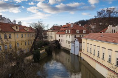 Watermill ve eski tarihi evler Kampa, Prague, Çek Cumhuriyeti, küçük nehir astar. Mavi sabah gökyüzü bulut ile.