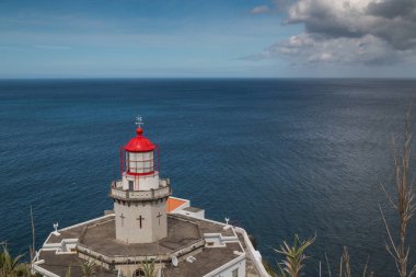 Deniz feneri Arnel Nordeste, Sao Miguel Island, Azor Adaları, Portekiz. Kırmızı çatı kulenin. Ufuk Atlantik Okyanusu'nun. Mavi gökyüzü kontrast bulutlar ile.