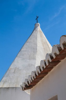 Eski kilise Nossa Senhora da Rocha Porches, Algarve, Portekiz, bir haç ile kulenin beyaz cephe beyaz. Çatı kiremitleri detayını. Parlak mavi gökyüzü.