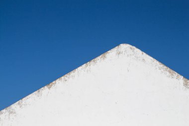 Beyaz bir cephe ile bir ev tarafında görüntülemek ve kenar çatı yanında yıpranmış. Parlak temiz mavi gökyüzü. Castro Marim, Algarve, Portekiz.