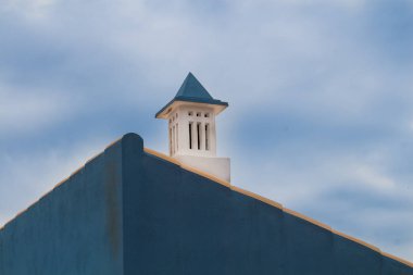 Yan duvar bir evin bir üçgen şekli ile mavi boyalı. Geleneksel Portekiz baca. Bulutlu gökyüzü. Lagos, Algarve, Portekiz.