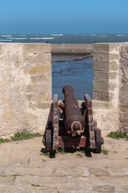 Eski Portekizli Kalesi El Jadida, Fas üzerinde Atlantik Okyanusu kıyısında. Taş duvar penceresinde tarihsel top. Parlak mavi gökyüzü.