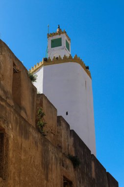 Top, kule, Ulu Camii eski Portekizli kalenin El Jadida, Fas. Ön planda yüksek bir duvar duvar. Parlak mavi gökyüzü.