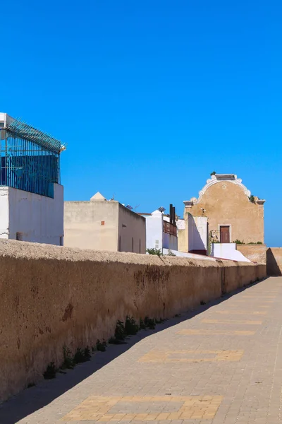 タイル張りの塀や家屋が並ぶ石畳の道 要塞のトップ 背景には旧シナゴーグ 明るい青い空 ジャディーダ モロッコの元のポルトガルの要塞 — ストック写真