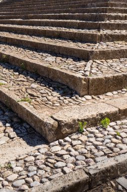 Merdivenlerden yapısını açık havada, onların köşe de dahil olmak üzere taştan yapılmış. Taşlar arasında küçük bitkiler. Güneşli bir gün. Estoi, Portekiz.