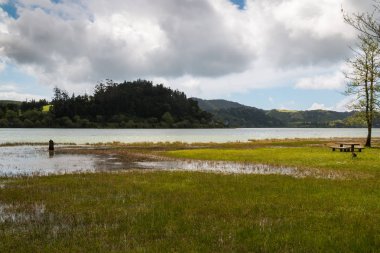Göl Lagoa das Furnas Sao Miguel Island, Azor Adaları, Portekiz. Taze bitki örtüsü sahile astar. Mavi gökyüzü yoğun bulutlar ile.
