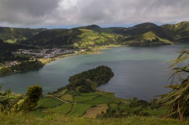 Yeşil Göl - Lagoa Verde Sete Cidades adlı. Taze yeşil bahar doğa. Tepeler ve dağlar göl çevresinde. Bulutlu gökyüzü. Sao Miguel, Azor Adaları, Portekiz.