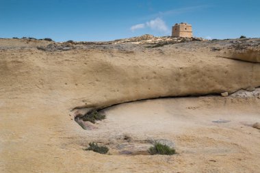 Kayalık ve kumlu Ülke adanın Gozo, Malta tarihi bir Dwejra Kulesi ile kuru. Mavi gökyüzü.