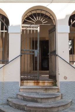 Güneş ışığı ile bir demir tarafından bir bina elightened duvarına kapısını açtı. Yuvarlak taş merdivenle. Tarihi şehir Vrbnik, Island Krk, Hırvatistan.