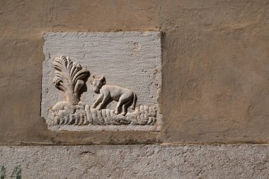 Bir cephe bir evin bir inek ve ağaç bir alanında gösterilen bir çini ile açık kahverengi renk. Tarihi şehir Vrbnik, Island Krk, Hırvatistan.