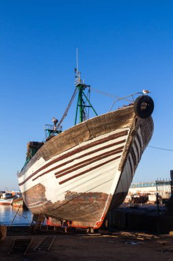 Sahilde Park Atlantik Okyanusu sudan ahşap balıkçı teknesi. Parlak bue sabah gökyüzü. Eski orijinal bağlantı noktası Essaouira, Morocco.