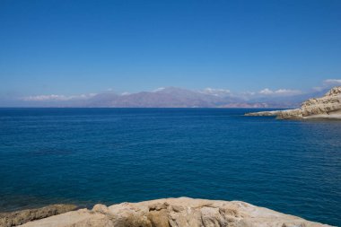 Deniz ve dağlarla kaplı bir manzara.