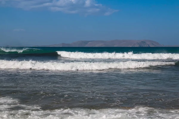 Θάλασσα με κύματα και ένα βουνό σε έναν ορίζοντα — Φωτογραφία Αρχείου